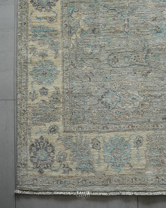 Corner of the light grey Chobi rug showing the cream floral border