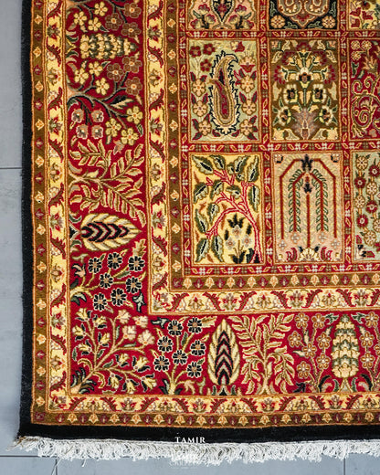 Corner of the Bakhtiari Black rug showing the red floral border, black edge and white fringe