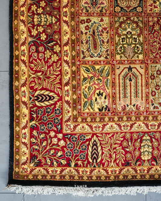 Corner of the Bakhtiari Black rug showing the red floral border, black edge and white fringe