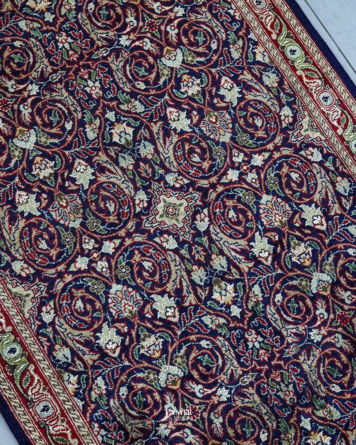 Angled view of scrolling vines and florals on the navy runner