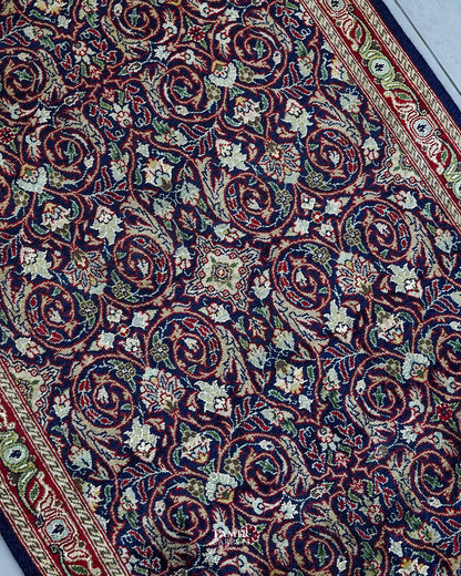 Angled view of scrolling vines and florals on the navy runner