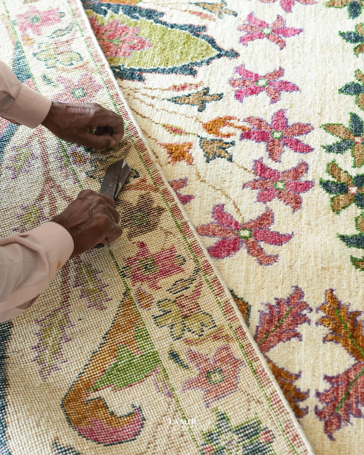 Craftsman hand-trimming the pile of the Bidjaar 9x12 handmade rug