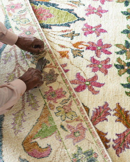 Craftsman hand-trimming the pile of the Bidjaar 9x12 handmade rug