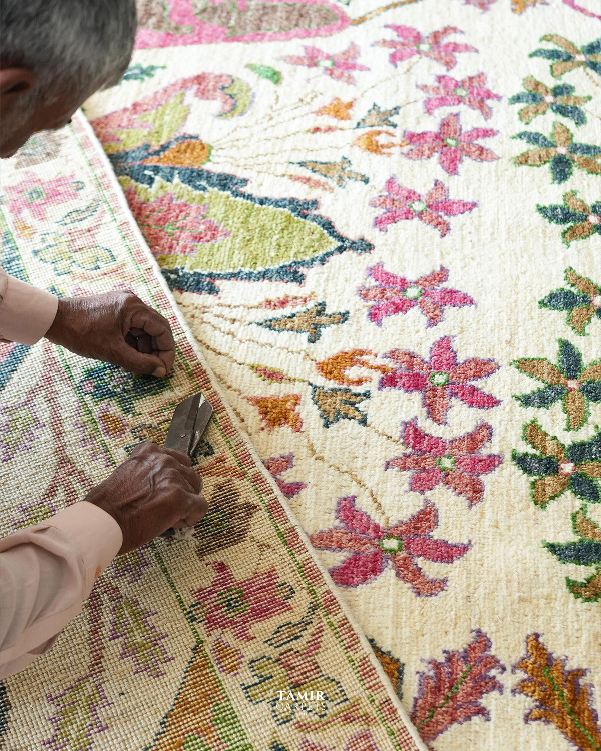Artisan hand-finishing the Bidjaar wool rug with shears