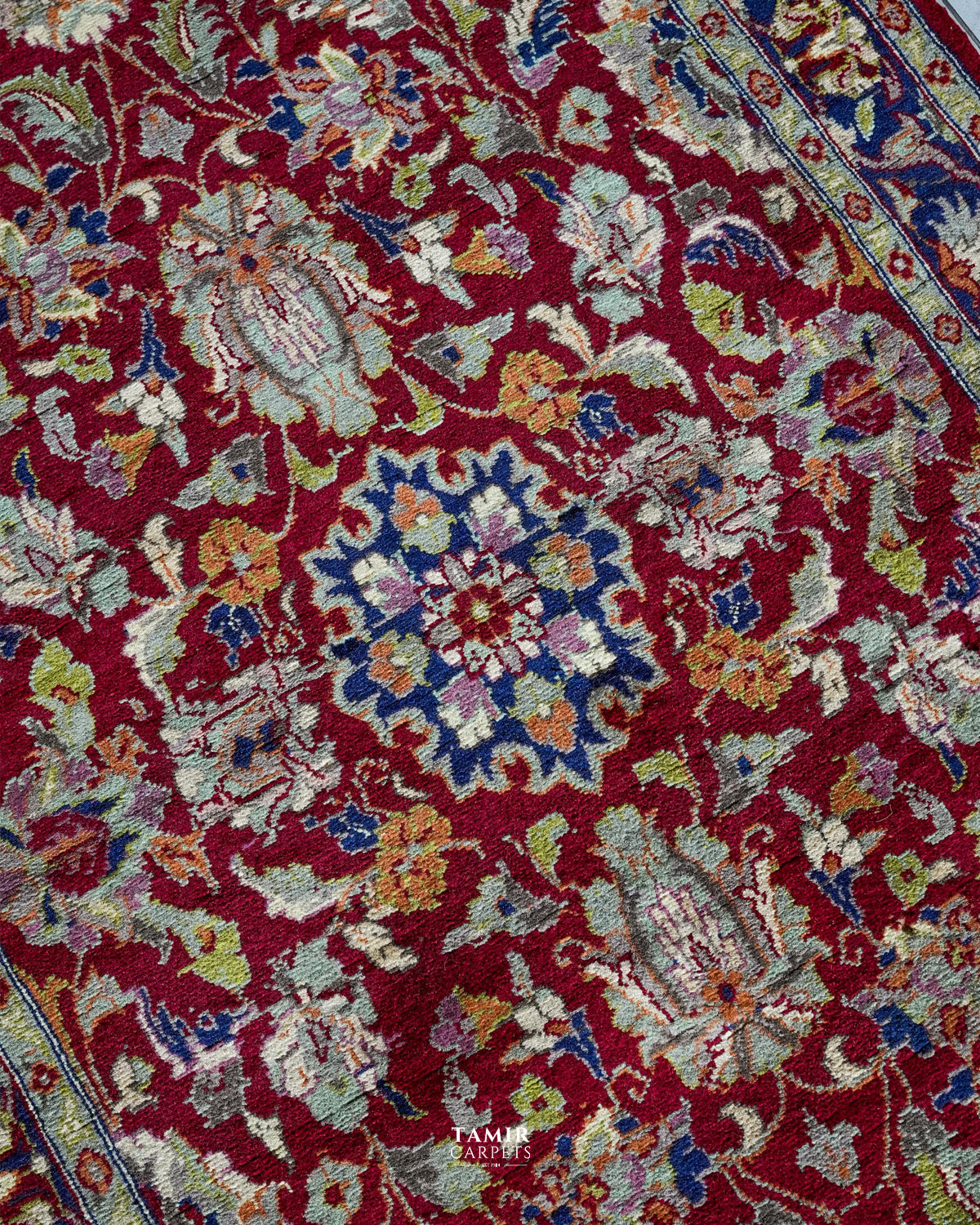 Close-up of floral motifs in organic-dyed handspun wool on the red Chobi rug