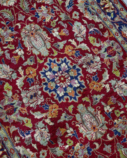 Close-up of floral motifs in organic-dyed handspun wool on the red Chobi rug