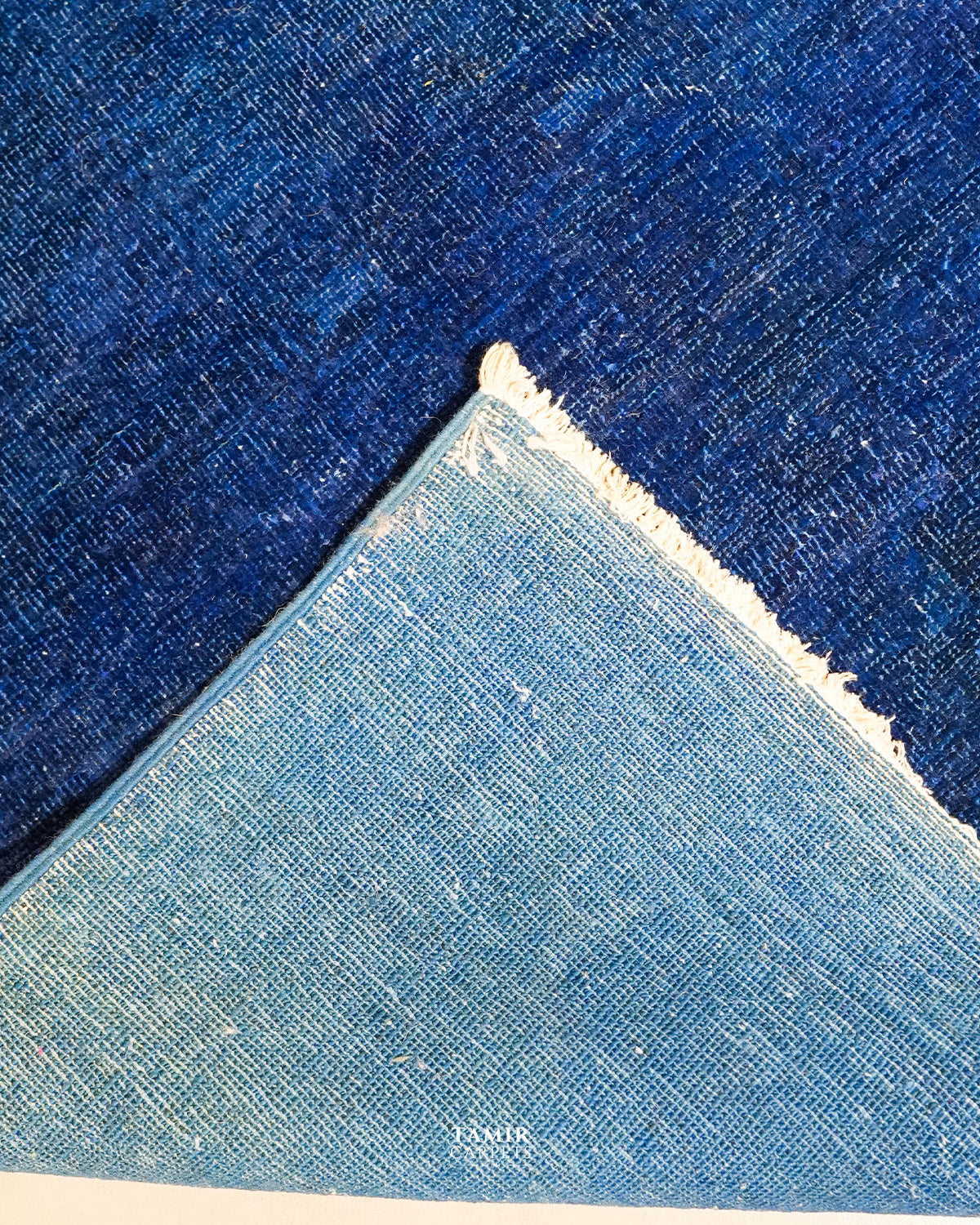 Folded corner showing the back weave of the double-knotted overdyed rug