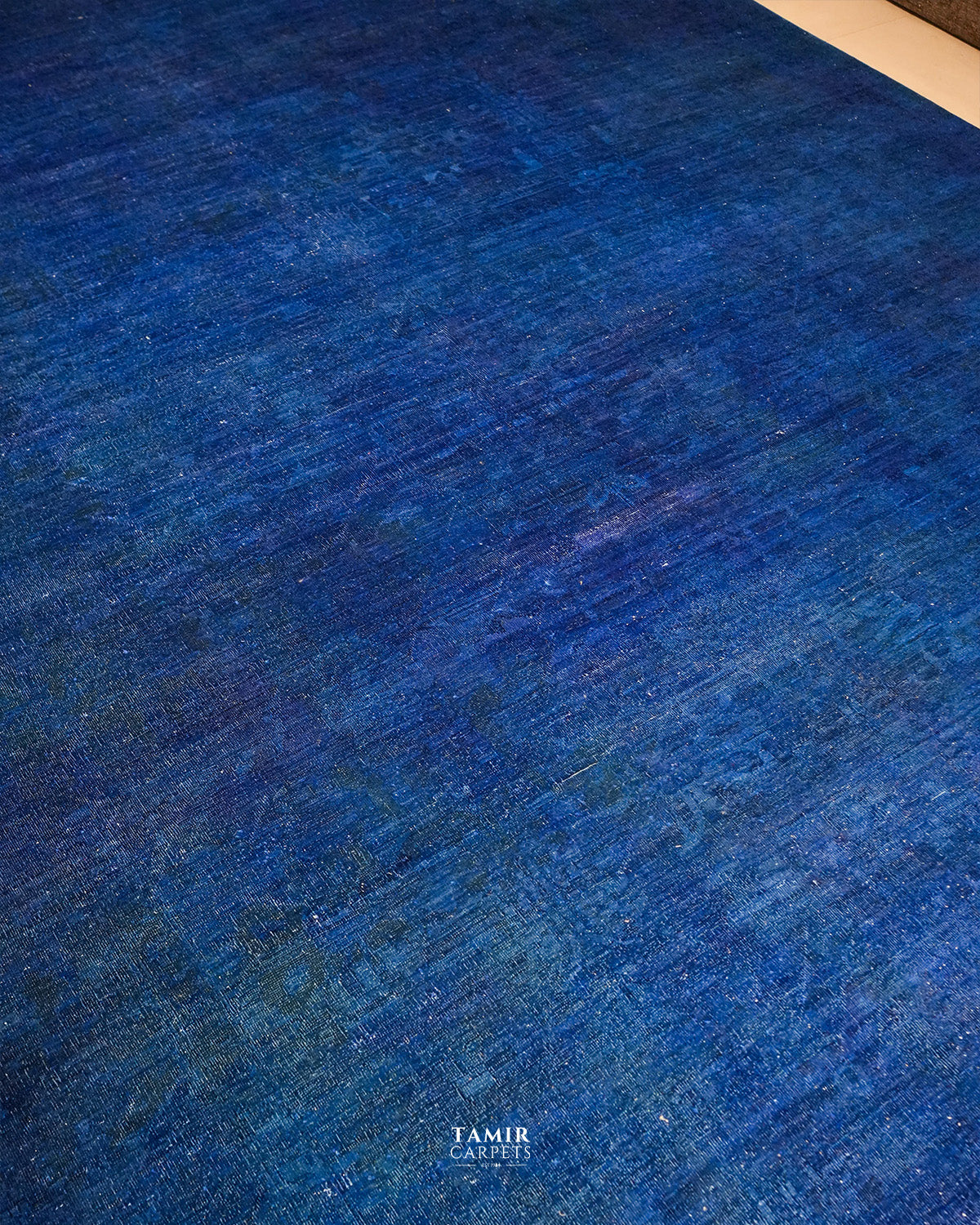 Royal blue overdyed field with faint traces of the original Chobi pattern