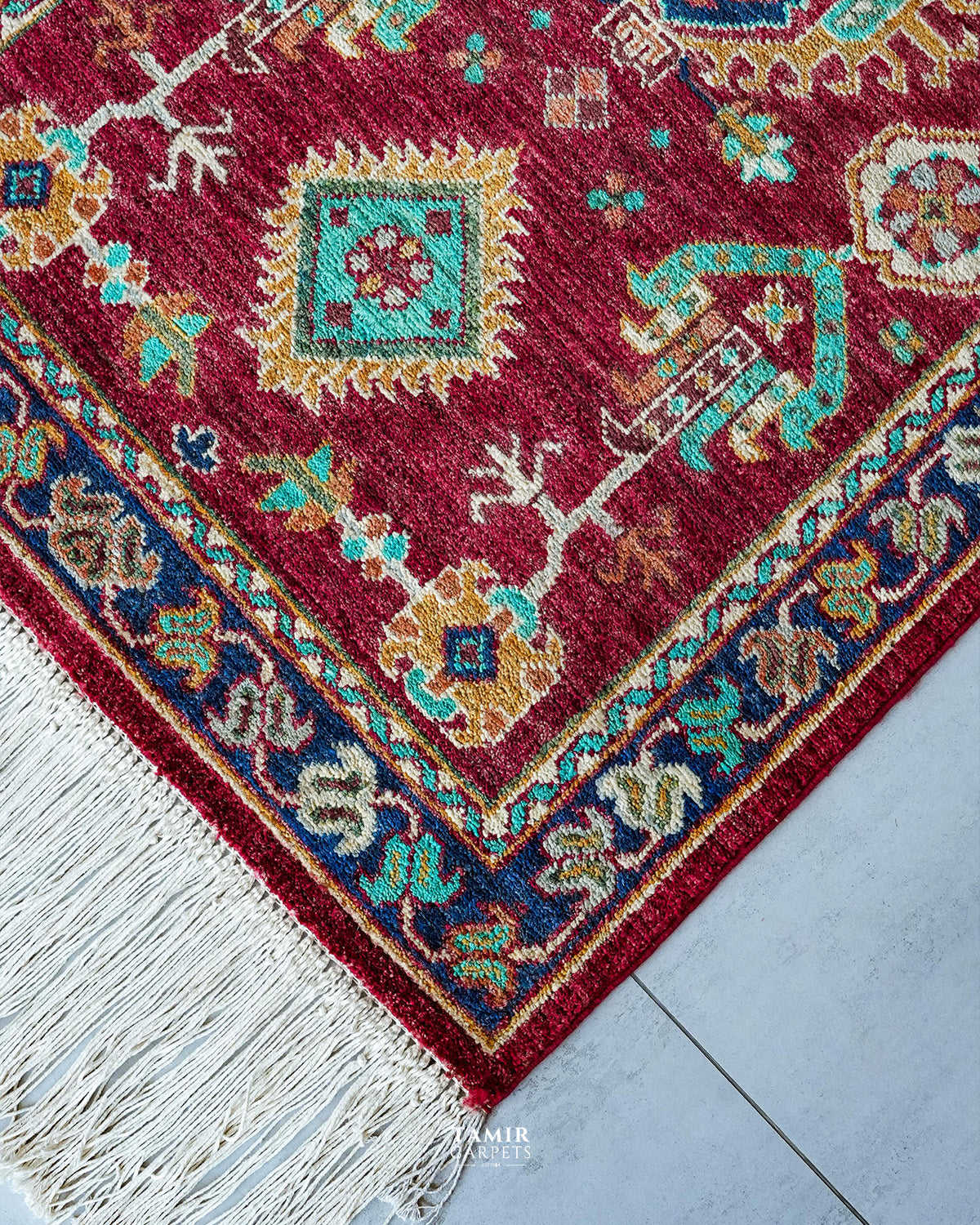 Corner of the red runner showing the navy border and fringe
