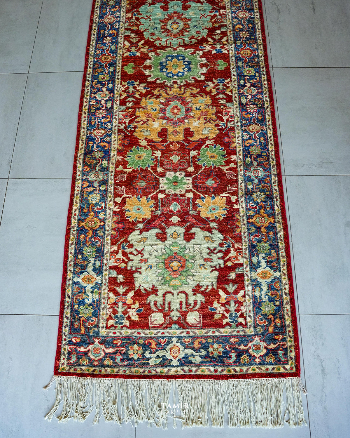 End section of the Chobi Runner with blue border and long fringe