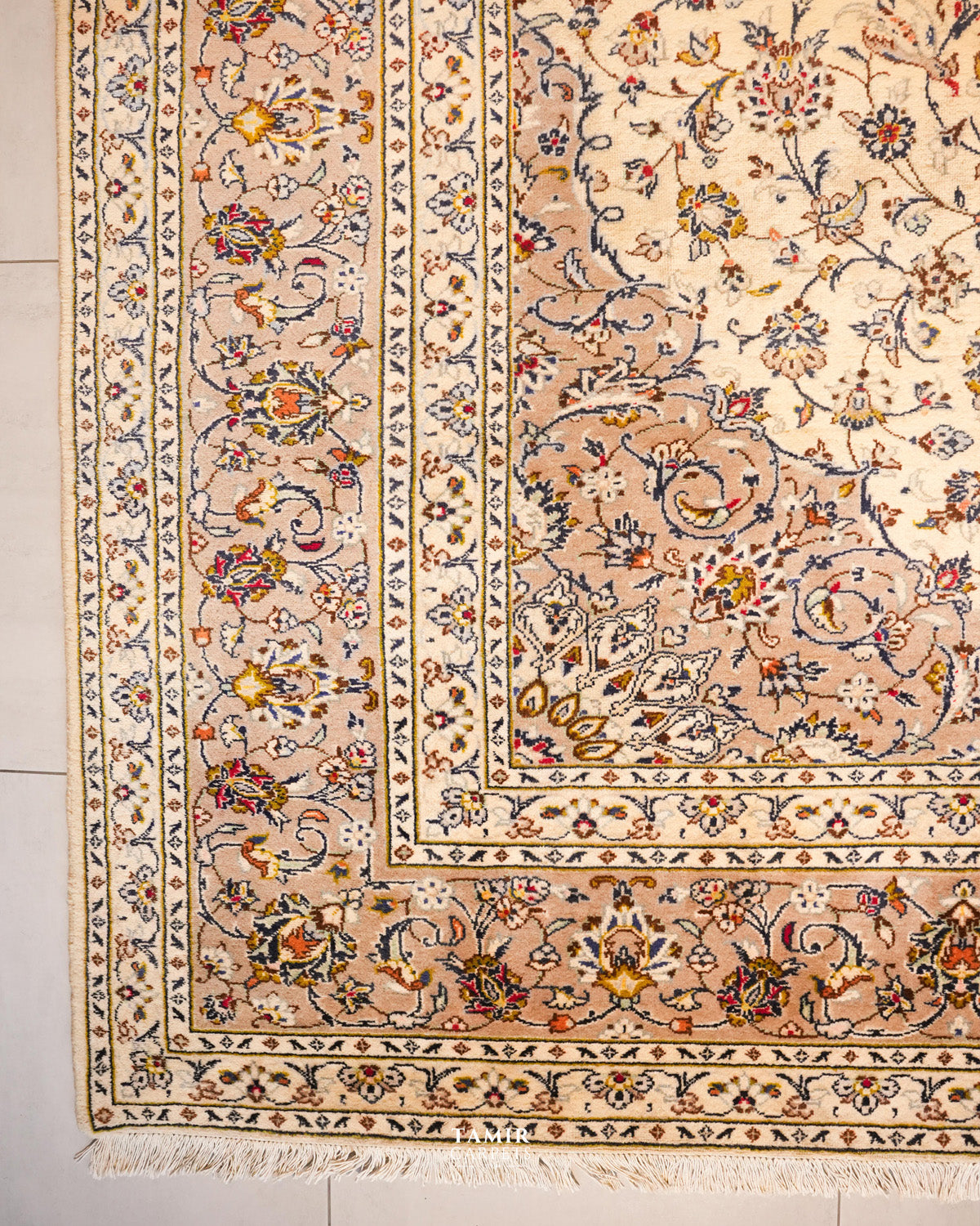 Corner of the Kashaan rug showing its layered floral borders and fringe