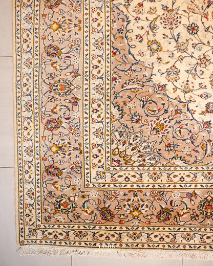 Corner of the Kashaan rug showing its layered floral borders and fringe