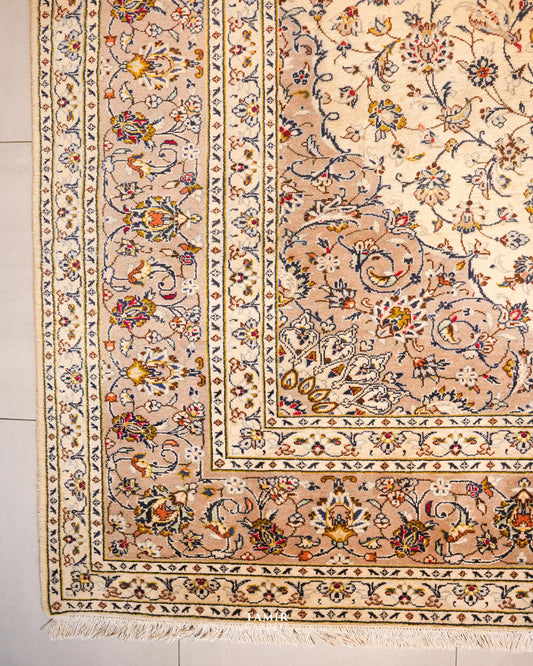 Corner of the Kashaan rug showing its layered floral borders and fringe