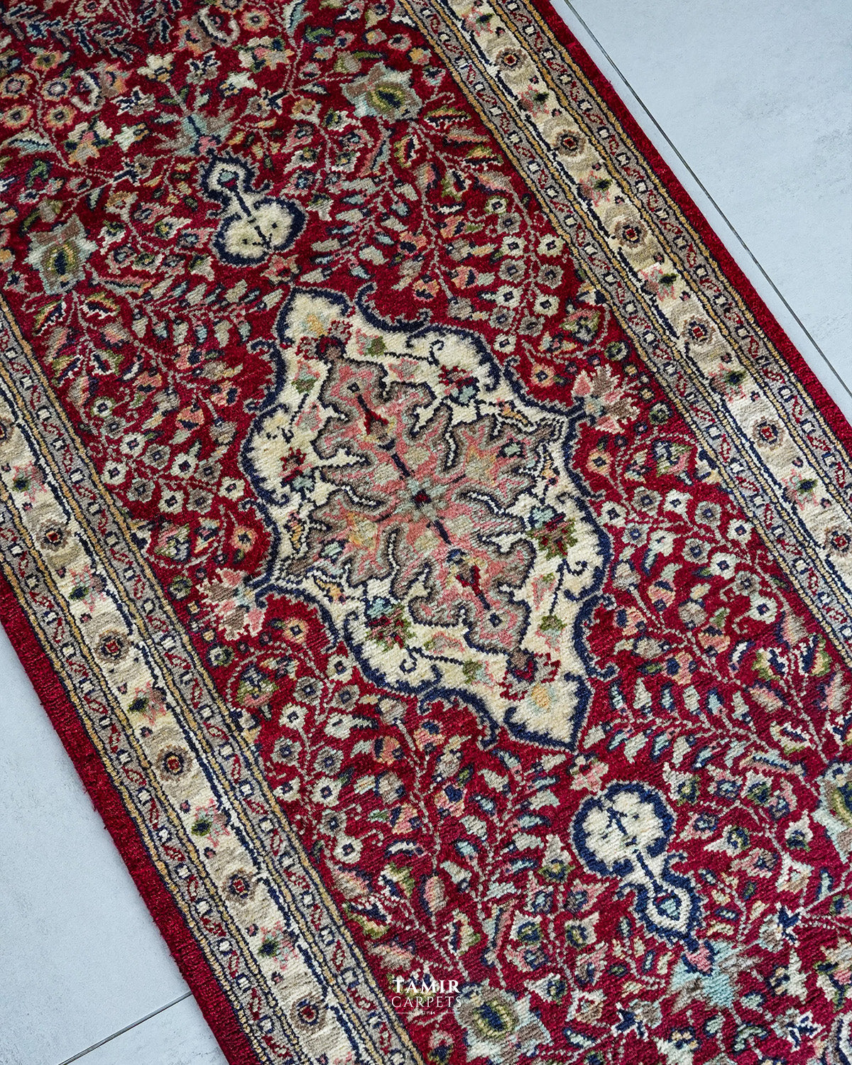Angled view of the medallion and floral vines in organic-dyed wool