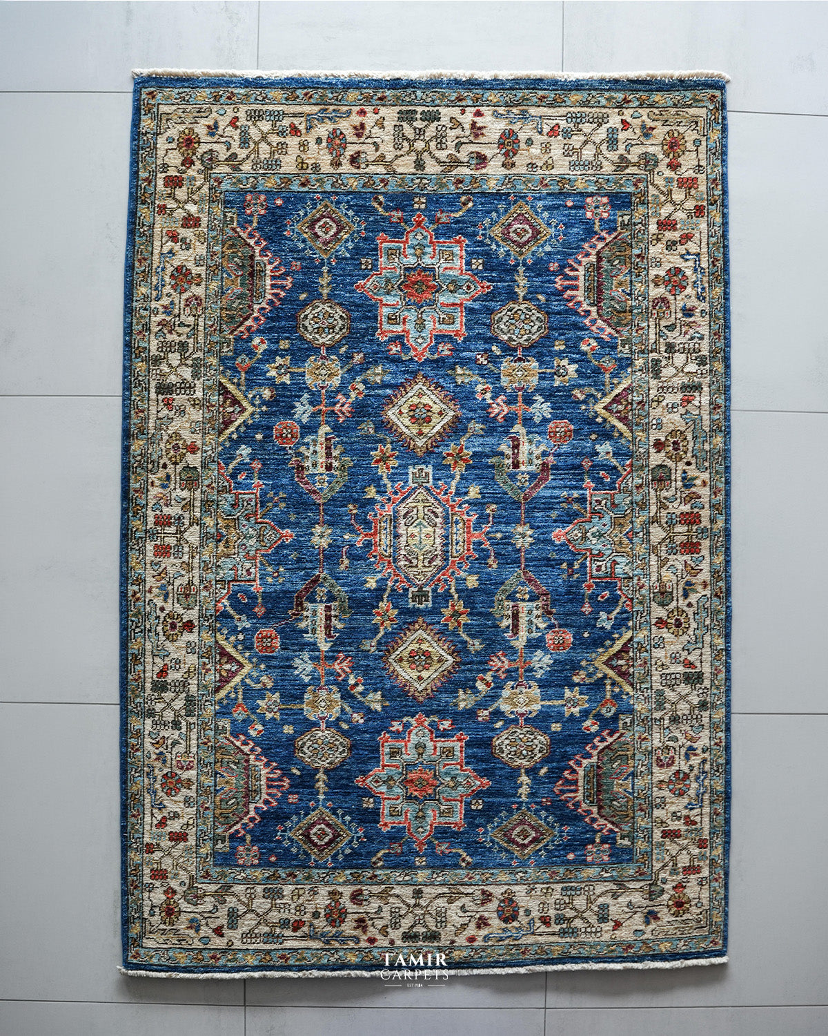 Top view of the Kazaak rug's blue field with red and aqua medallions