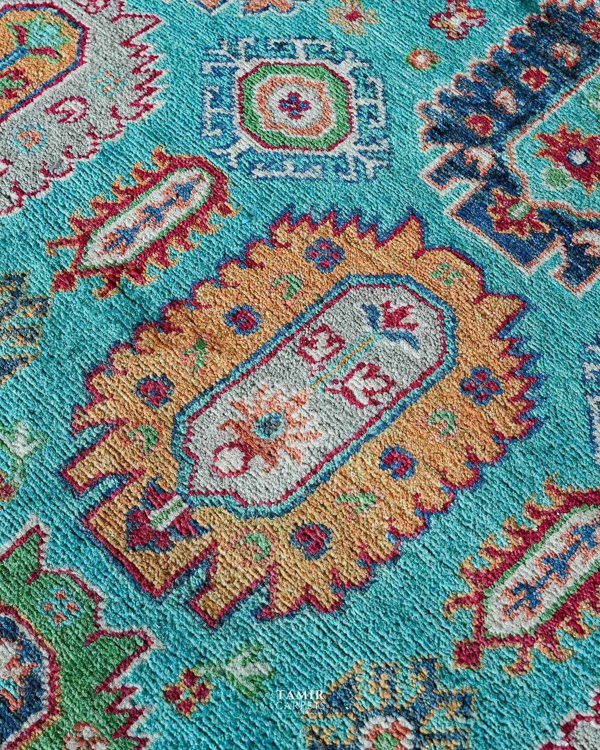 Close-up of an orange tribal medallion in organic-dyed handspun wool