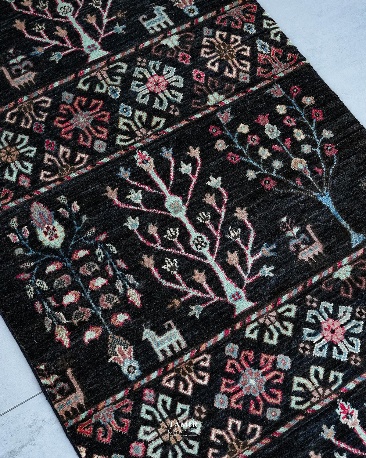 Angled view of floral bands and tree-of-life motifs on the Khurjeen Runner