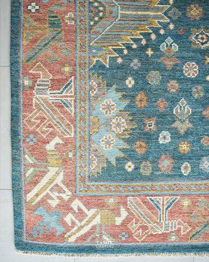 Corner of the blue and pink Oushak rug showing the geometric border
