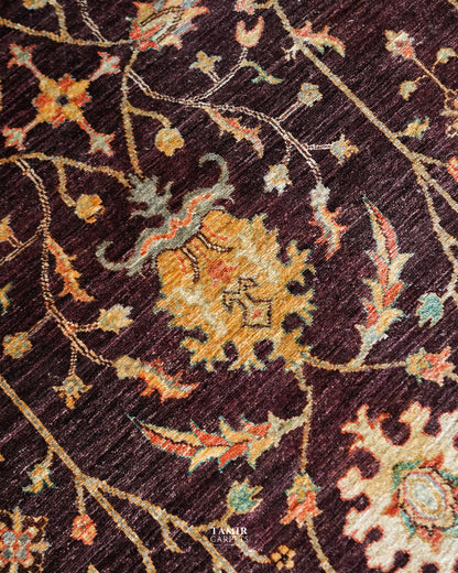 Detail of flowing floral vines across the brown Oushak Afghan rug