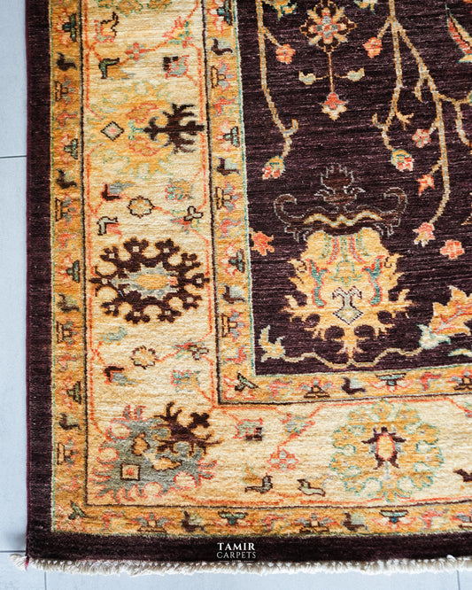 Corner of the brown Oushak rug showing the wide golden border