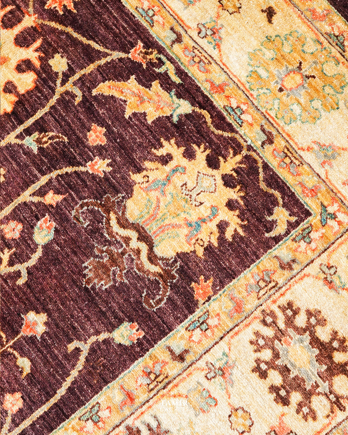 Brown field meeting the golden border on the handmade Oushak rug
