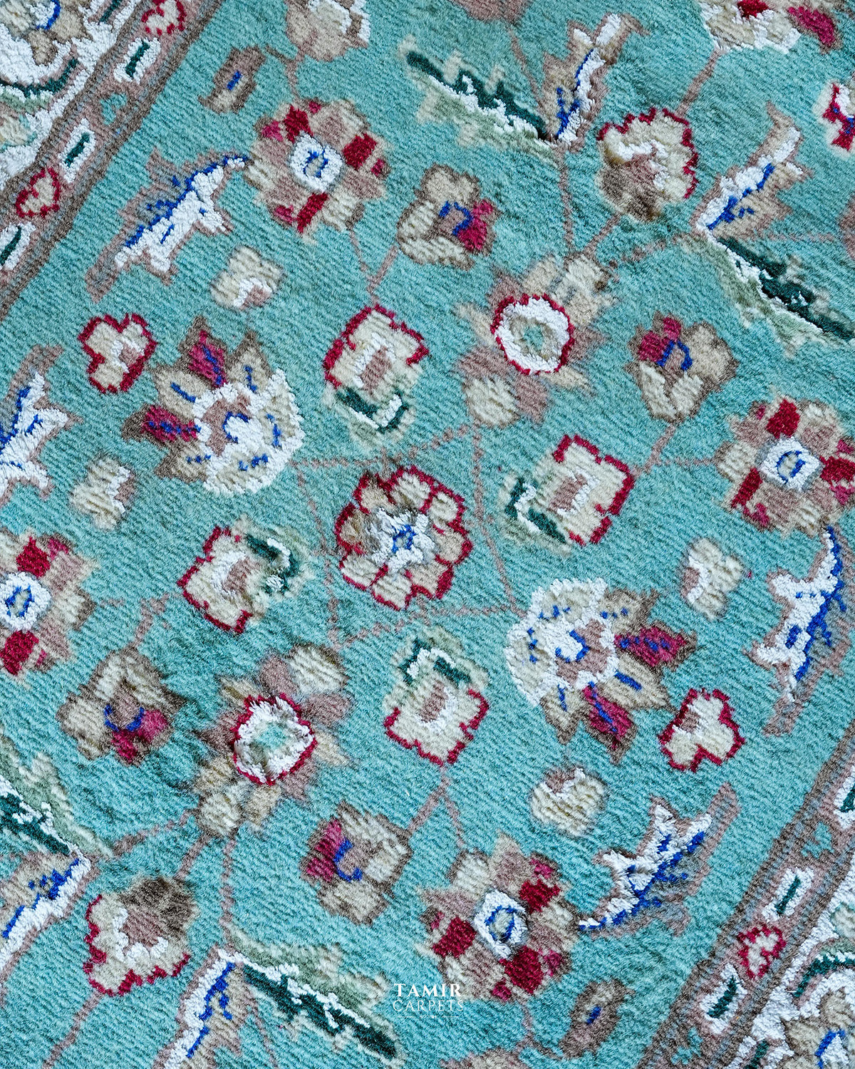 Close-up of red and cream floral motifs in organic-dyed handspun wool