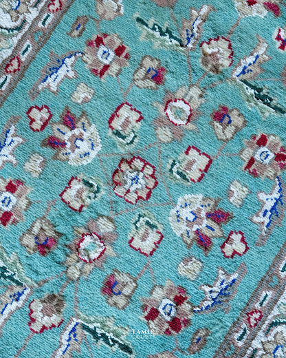 Close-up of red and cream floral motifs in organic-dyed handspun wool