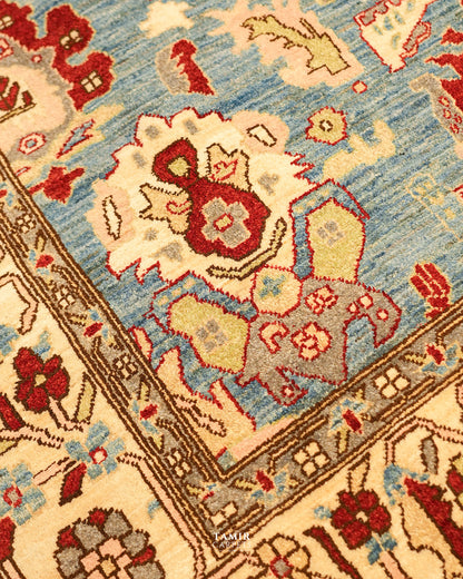 Close-up of red and cream floral motifs on the sky blue Sultanabad field