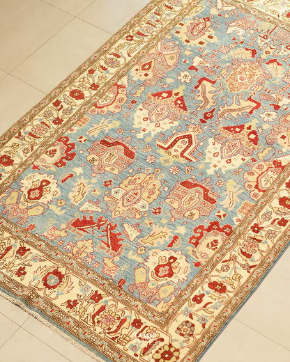 Angled view of the Sultanabad rug's red and cream palmette design