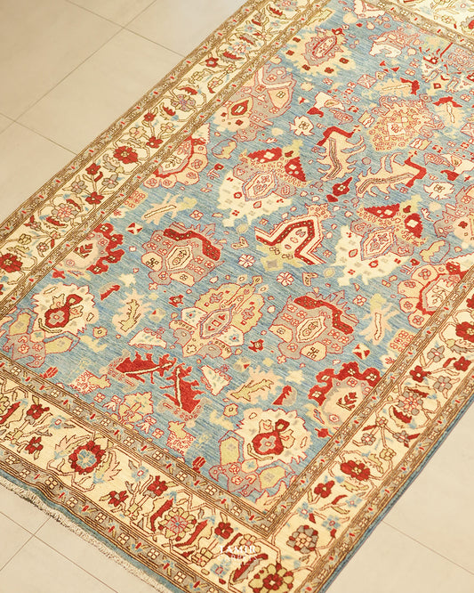 Angled view of the Sultanabad rug's red and cream palmette design